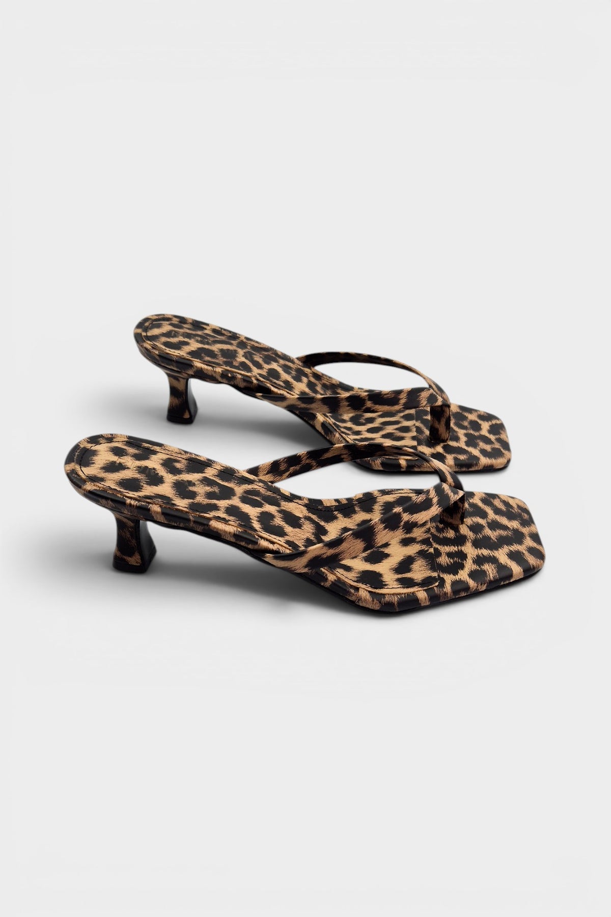 Cheetah print thong mule heels with matching insoles and kitten heels.