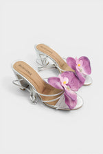 Silver slip-on sandal heels with lavender silk orchid flower accents.