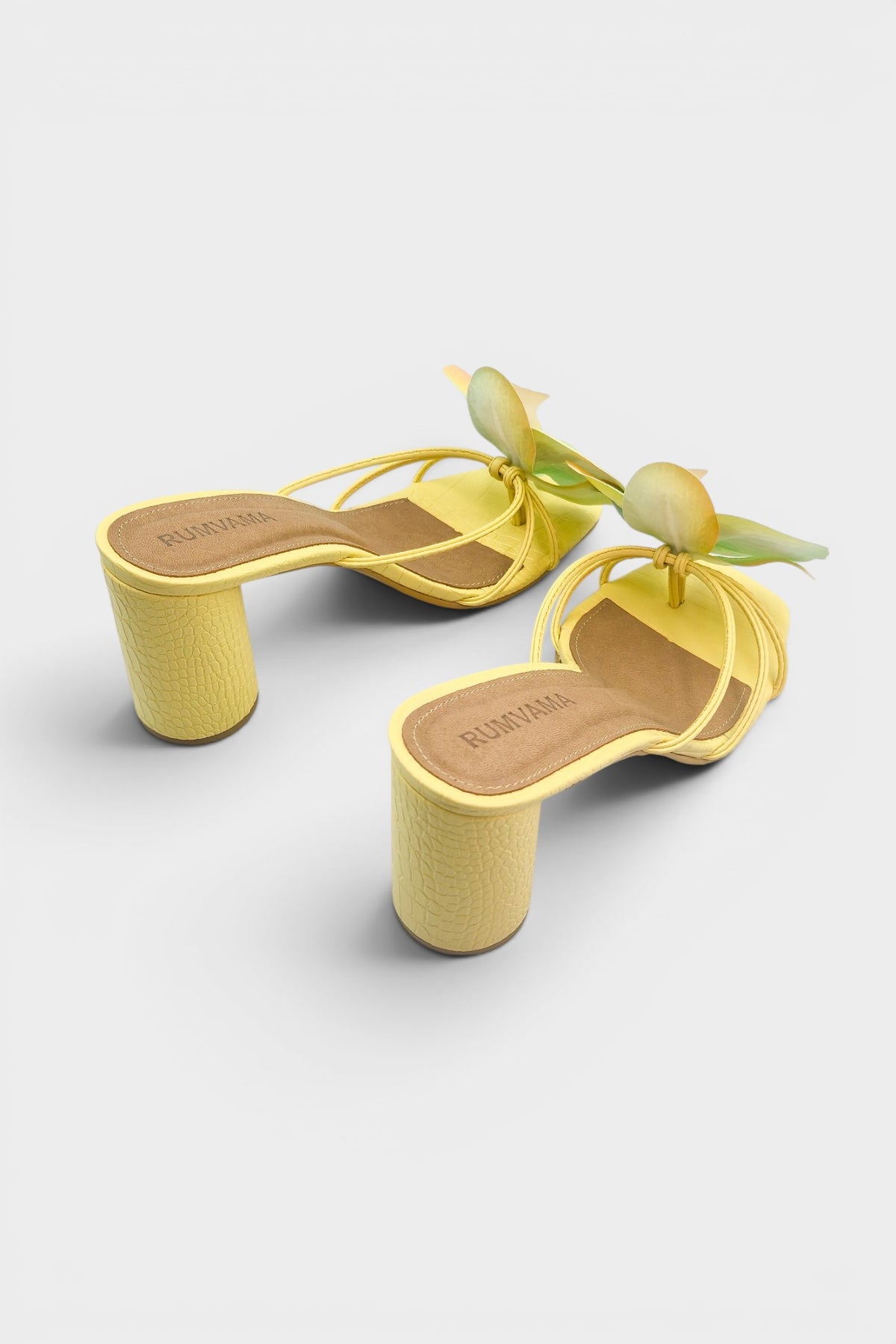 Yellow slip-on sandal heels with printed orchid flower accents.