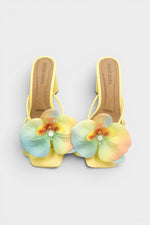 Yellow slip-on sandal heels with printed orchid flower accents.