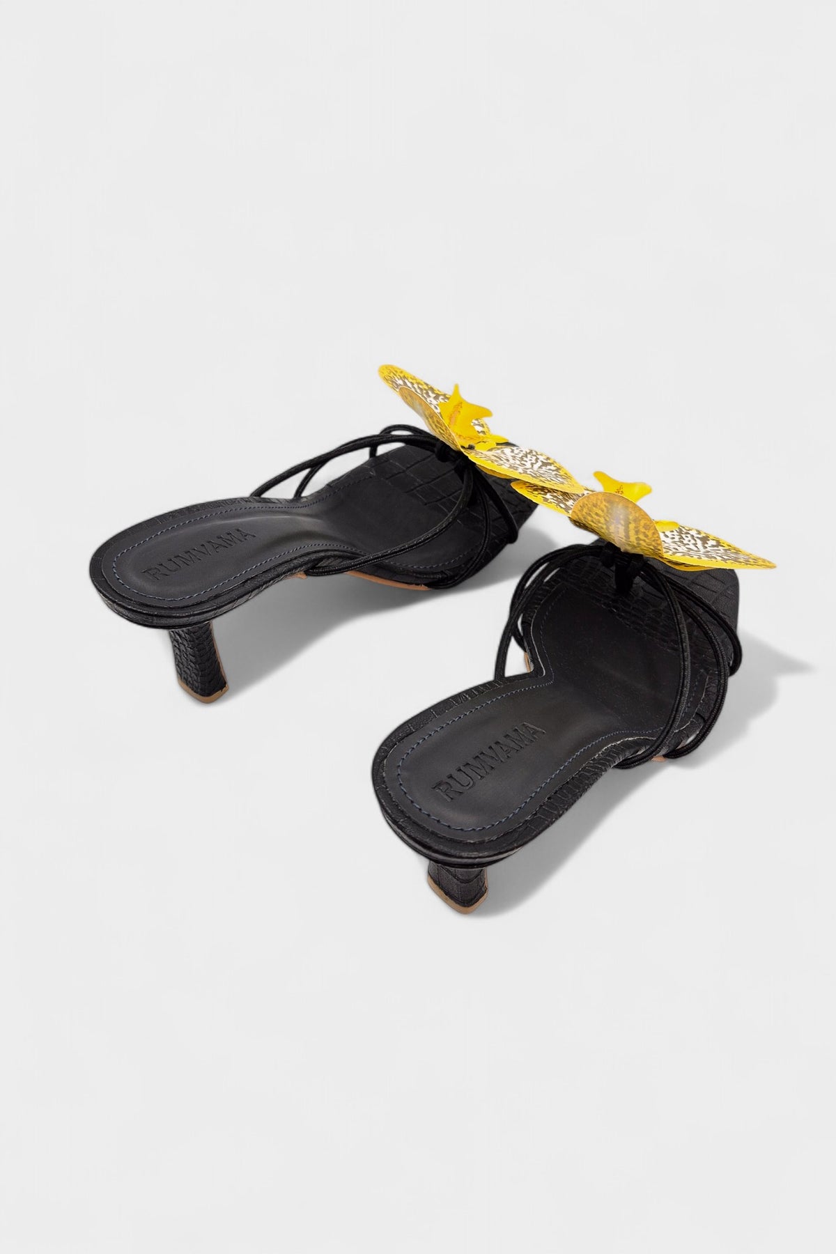 Black slip-on sandal heels with printed orchid flower accents.