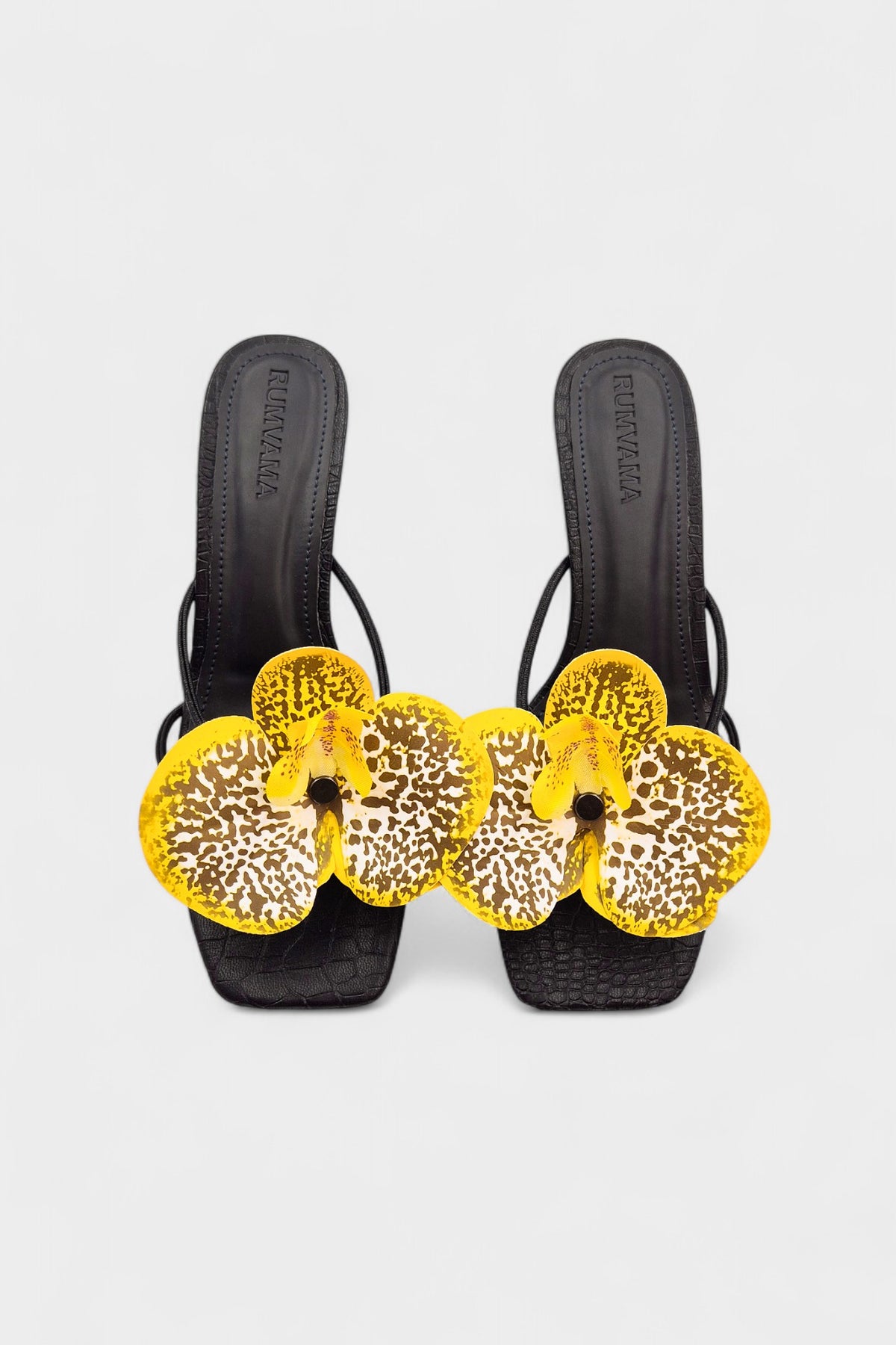 Black slip-on sandal heels with printed orchid flower accents.