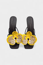 Black slip-on sandal heels with printed orchid flower accents.