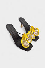 Black slip-on sandal heels with printed orchid flower accents.