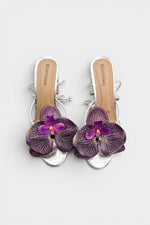 Silver slip-on sandal heels with purple silk orchid flower accents.