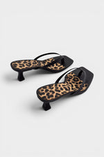 Black thong sandal mules with cheetah print insoles and kitten heels.