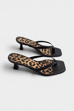 Black thong sandal mules with cheetah print insoles and kitten heels.