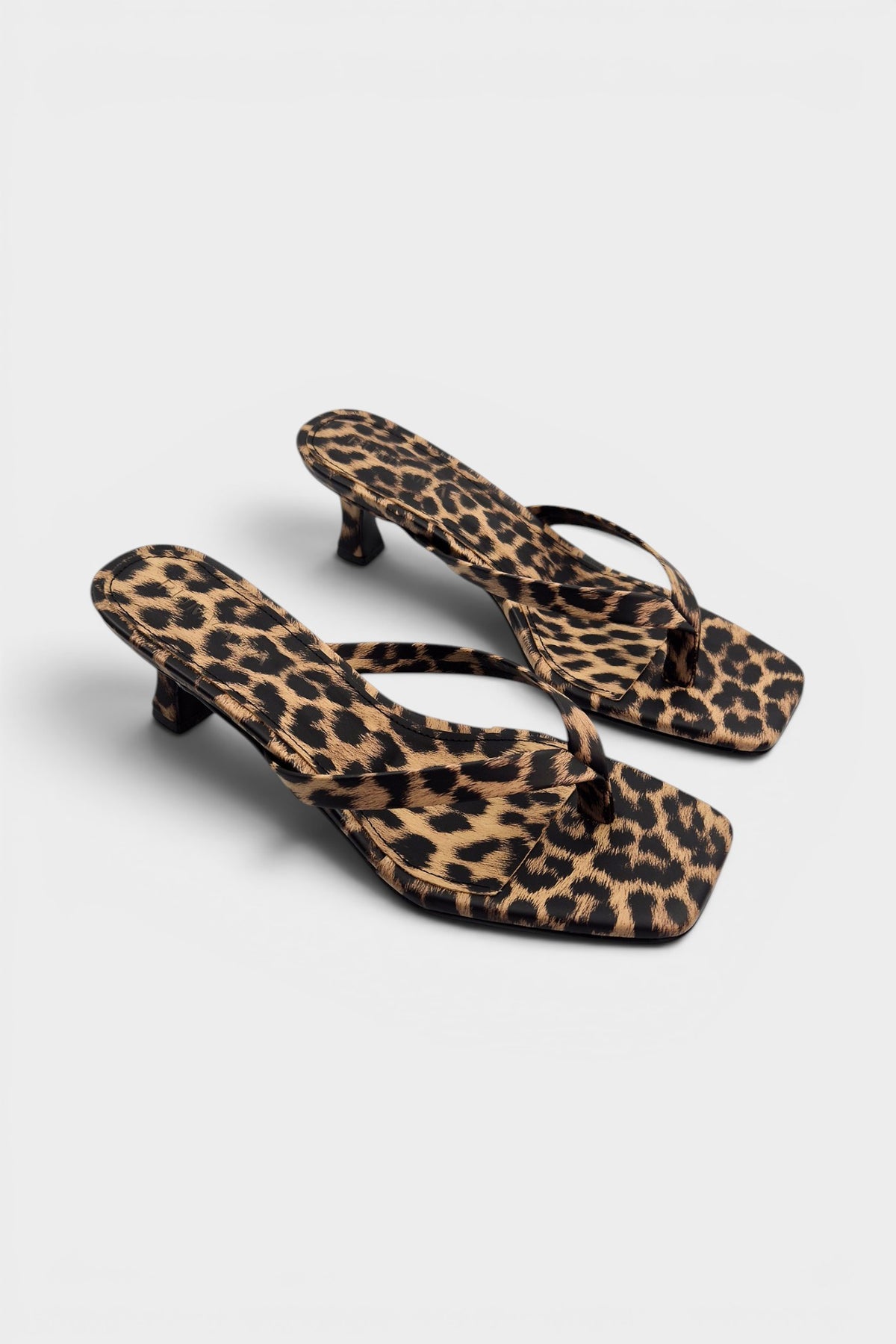 Cheetah print thong mule heels with matching insoles and kitten heels.