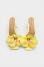 Yellow slip-on sandal heels with printed orchid flower accents.