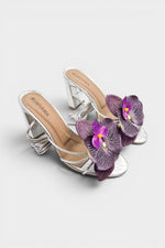 Silver slip-on sandal heels with purple silk orchid flower accents.