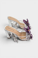 Silver slip-on sandal heels with purple silk orchid flower accents.